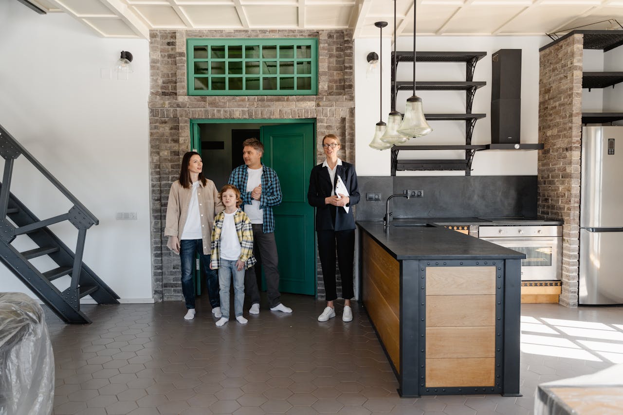 why-choose-us A family with a realtor viewing a modern industrial-style kitchen in a new home.